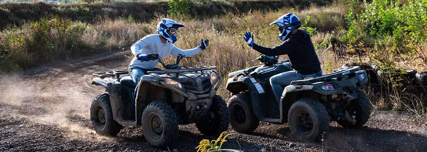 zwei Quadfahrer geben sich während der Fahrt High-Five